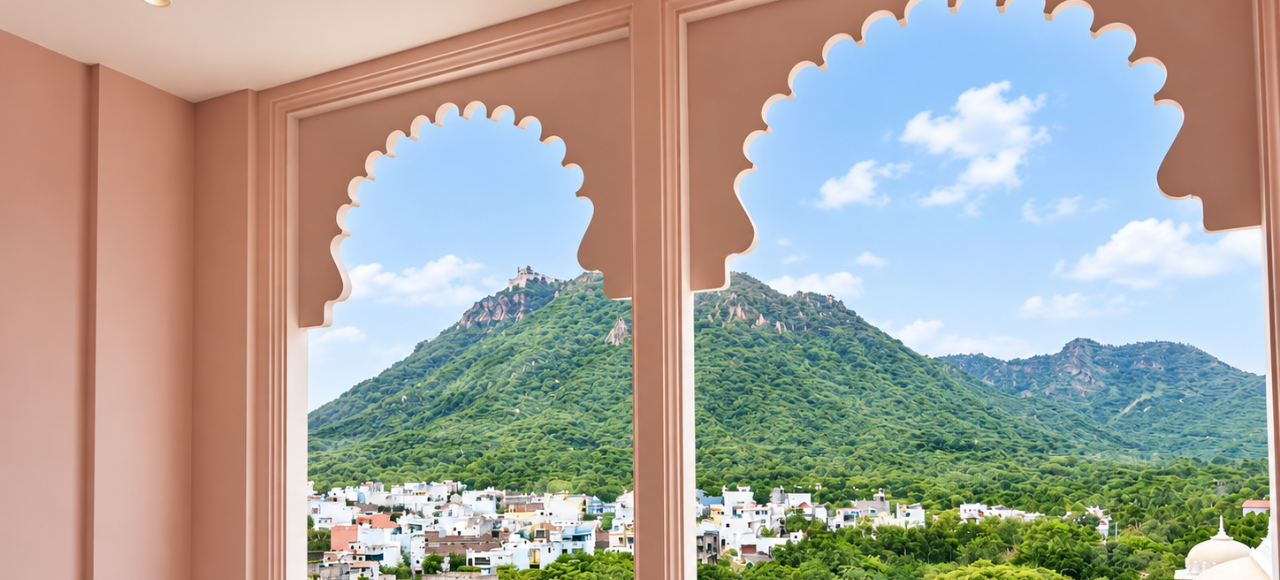 View through pink scalloped-arch windows of a green hill and white buildings under a blue sky.